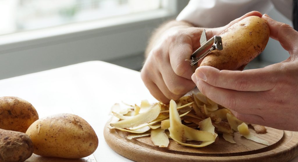 preparazione e pelatura delle patate all'interno della cucina di un ristorante
