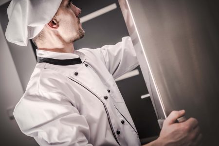 Chef che sceglie gli ingredienti presenti nel frigo della sua cucina
