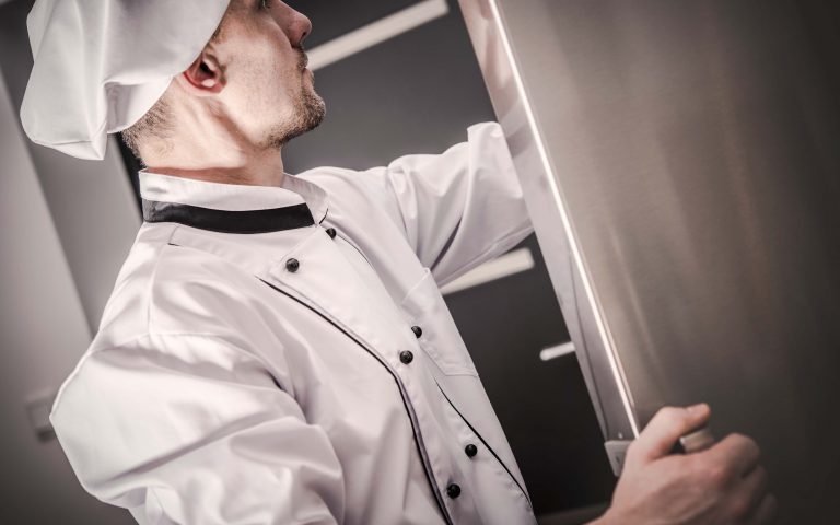 Chef che sceglie gli ingredienti presenti nel frigo della sua cucina